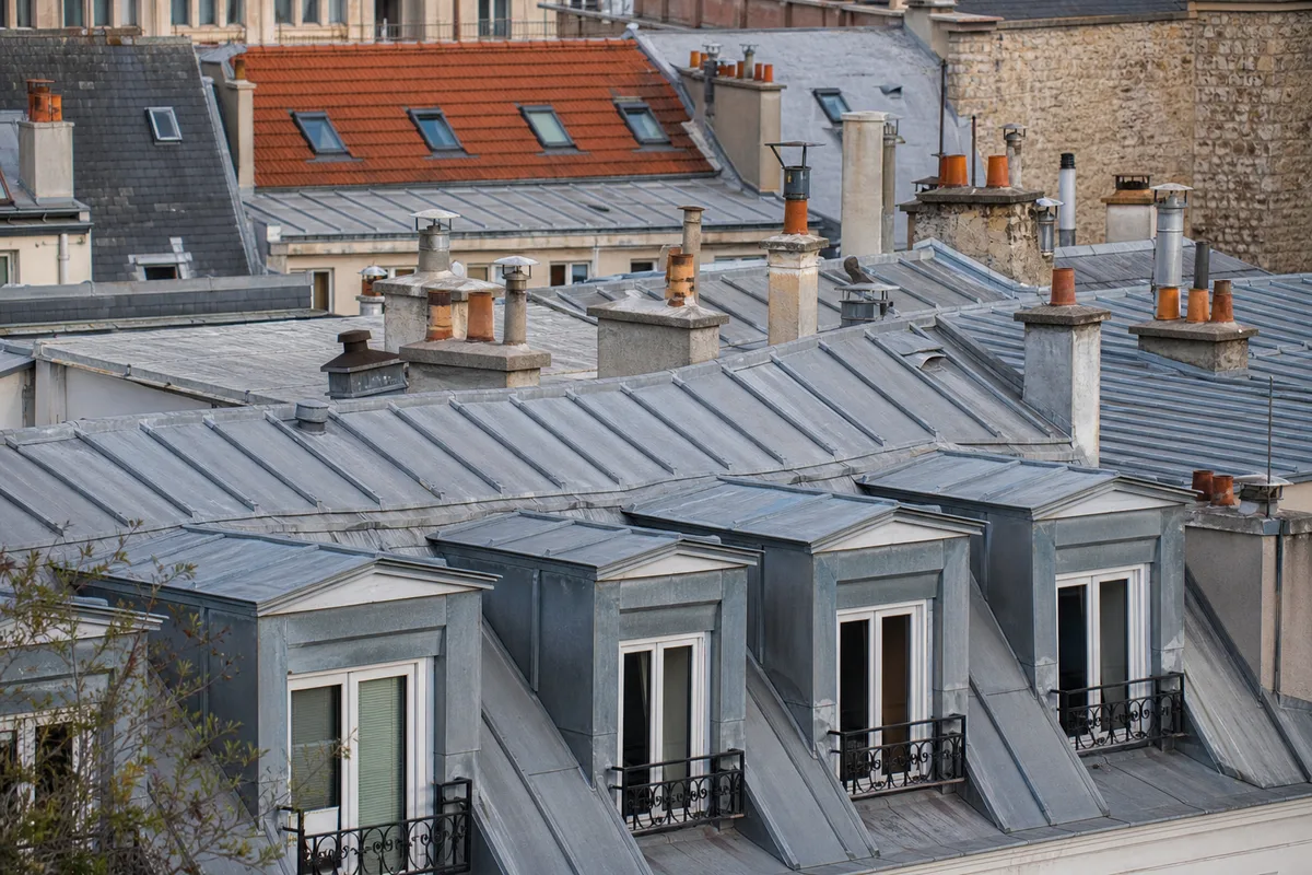 Toiture en zinc d&rsquo;un immeuble parisien avec lucarnes et souches de cheminée
