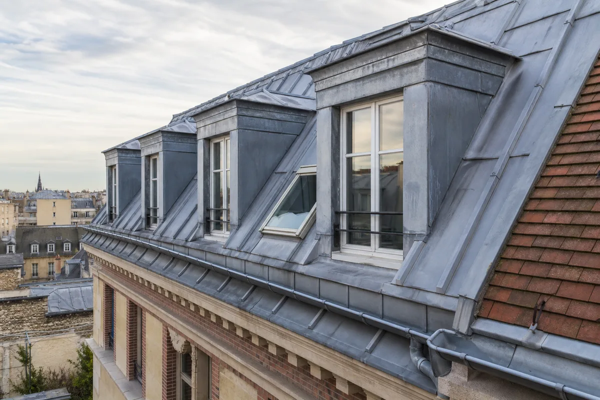 Toiture en zinc d’un immeuble parisien avec lucarnes et chéneau